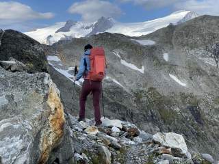 Frau wandert auf Steinweg mit Blick auf Großvenediger