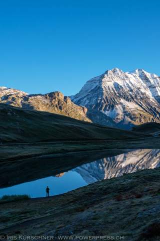 See, in dem sich Bergmassiv spiegelt