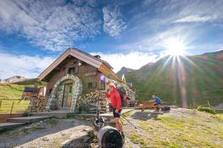 Wanderer vor kleiner Berghütte