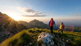 Zwei Wandernde genießen die Aussicht vom Gipfel