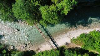 Fußgängerbrücke die über einen Fluss führt aus der Vogelperspektive.