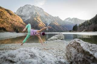 Frau macht Yoga vor Bergsee