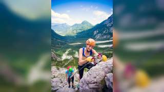 Blick ins Tal vom Klettersteig aus gesehen, zwei Menschen hängen ihre Sicherungen ein.