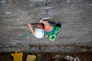 Lena Müller beim Klettern in der Wand. Blick von oben auf sie herunter.