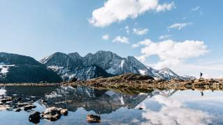 Blick über einen See, im Hintergrund das Gipfelmeer.
