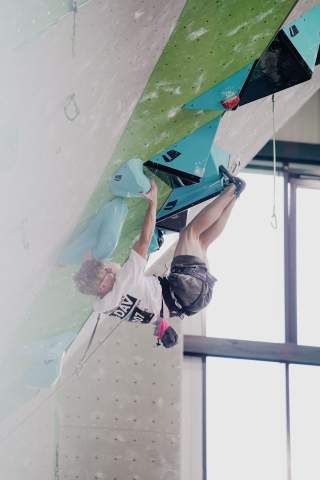 Wettkampfkletterer Otto Reiter hängt an seinen Zehenspitzen an einer künstlichen Kletterwand.