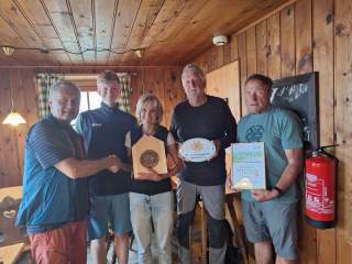 Fünf Personen bei der Verleihung des Umweltgütesiegels in der Hütte