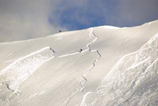 Verschneiter Hang, man kann sehen, dass ein großes Schneebrett abgegangen ist