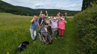 Gruppenfoto von Menschen mit und ohne Behinderung in einer Wiese