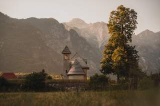 Kleine Kapelle im Abendlicht vor Bergen