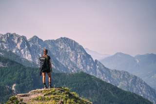 Frau genießt Ausblick in Berglandschaft
