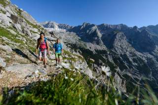 Frau und Mann wandern bei Sonnenschein in den Bergen