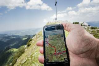 Hand hält Smartphone mit Tourenplanungs-App
