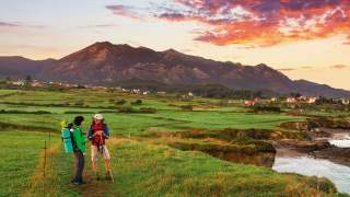 Zwei Wanderer stehen an der Steilküste in der Abendsonne.