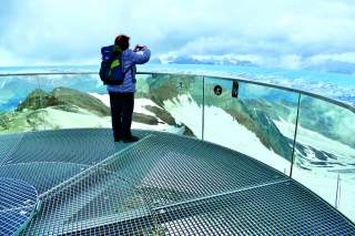 Frau auf einer Plattform fotografiert Bergpanorama