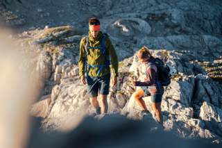 Zwei Bergsteiger:innen im Aufstieg