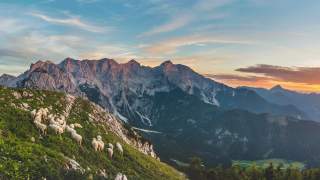 Blick ins Tal vom Klettersteig aus gesehen, zwei Menschen hängen ihre Sicherungen ein.
