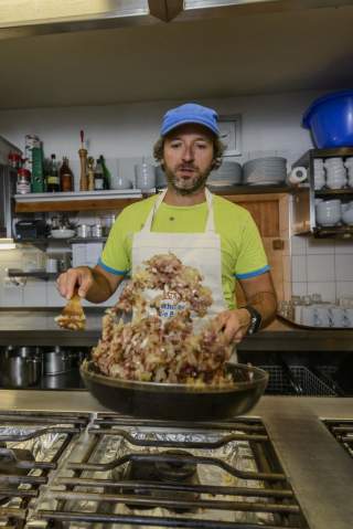 Hüttenwirt beim Kochen