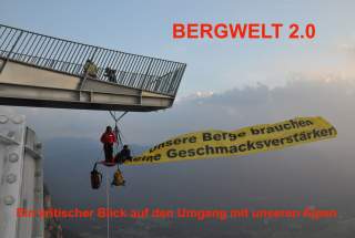 Menschen hängen mit Plakat in Portaledge unter Stahlkonstruktion in den Bergen