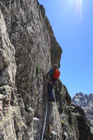 Mann beim Klettern an Felswand