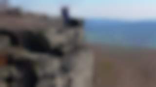 Eine Frau auf dem flachen Felsvorsprung des Hohen Schneebergs.
