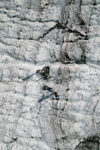 Luftaufnahme von Menschen, die mit Geräten einen Gletscher vermessen