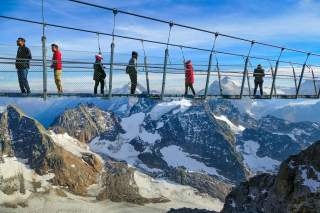 Hängebrücke in den Alpen, über die Menschen laufen Hängebrücke in den Alpen, über die Menschen laufen