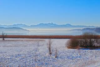 Winter am See mit Bergen im Hintergrund