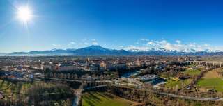 Ein klarer Spätwintertag: Areal view auf die Stadt Cuneo, im Hintergrund schneebedeckte Berge.