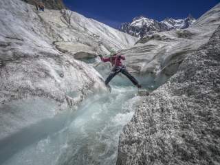 Bergsteigerin auf einer Seilbrücke über einen Gletscher Bergsteigerin auf einer Seilbrücke über einen Gletscher