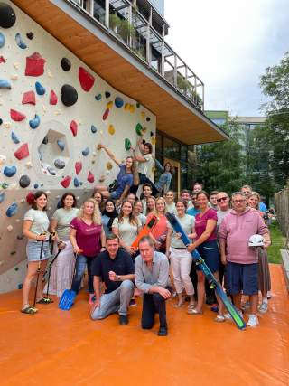 Das Team des DAV Summit Club vor einer Boulderwand.