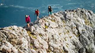 Drei Menschen wandern auf Berggrat