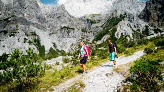 Menschen wandern durch Berglandschaft