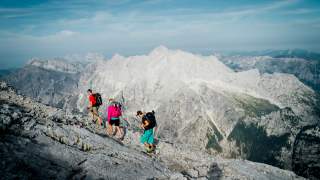 Drei Menschen wandern in alpinem Gelände