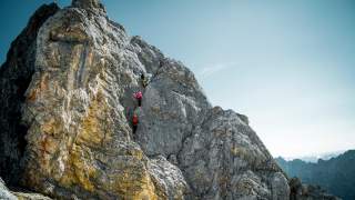 Drei Bergsteigende im Fels