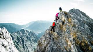 Drei Bergsteigende an Grat