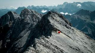 Berggrat mit roter Biwakschachtel
