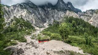 Ein Bus der am Fuße der Berge entlang fährt.