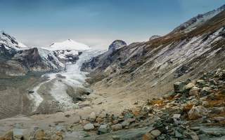 Die Pasterze. Die Pasterze zieht sich zurück, zu sehen sind Geröll und der abtauende Gletscher.