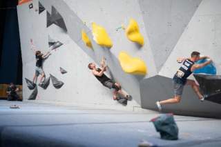 Drei Kletternde am Boulder