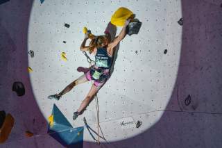 Eine Wettkampfkletterin im Vorstieg an einer künstlichen Kletterwand