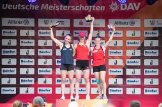 Drei Athletinnen halten ihre Pokale bei der Siegerehrung.