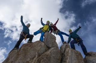 Vier Frauen mit Kletterausrüstung auf Felsen