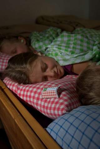 Kinder schlafen auf Hütte in Matratzenlager