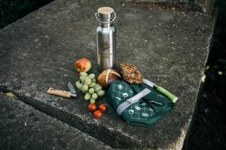 Brotzeit auf Stein mit Obst, Gemüse und Trinkflasche