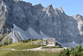 Berghütte vor Felswänden