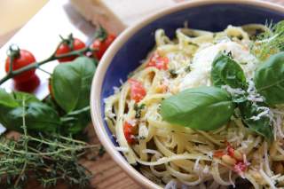 Teller mit Nudeln mit Tomaten, Parmesan und Basilikum