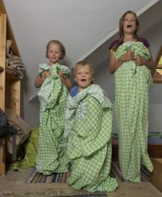 Drei Kinder mit Hüttenschlafsäcken in Hütte