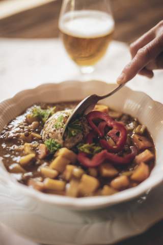 Berglinsenragout mit Semmelknödel angerichtet auf einem Teller