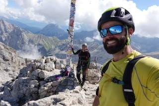Zwei Männer machen Selfie mit Gipfelkreuz